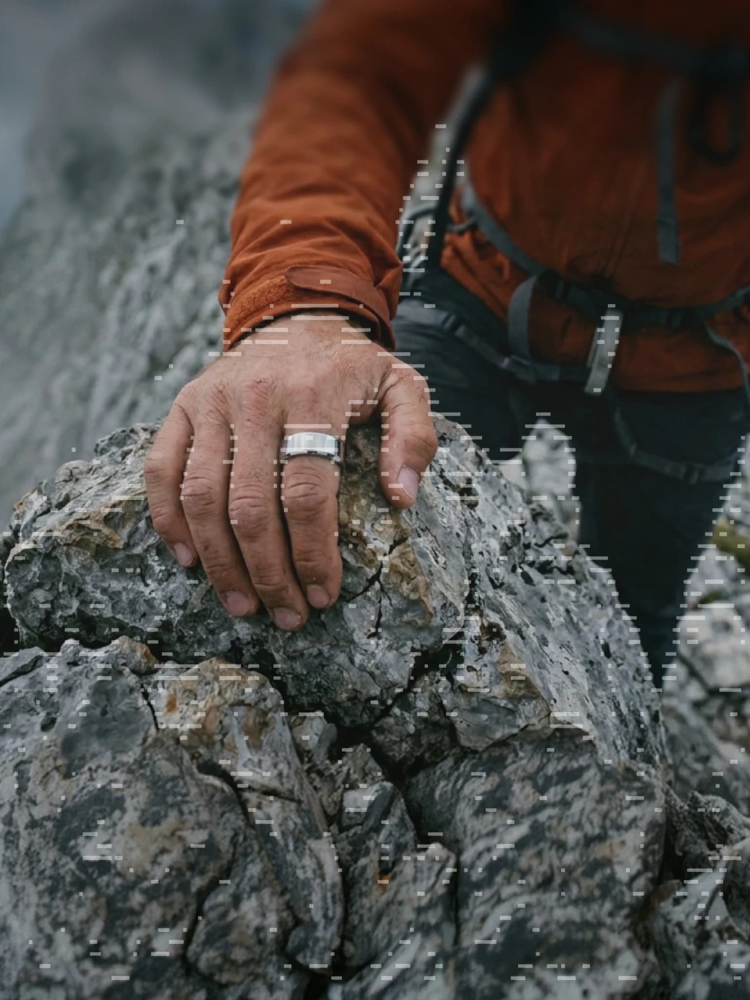 A climber’s hand on a rock, wearing the Ultrahuman Ring