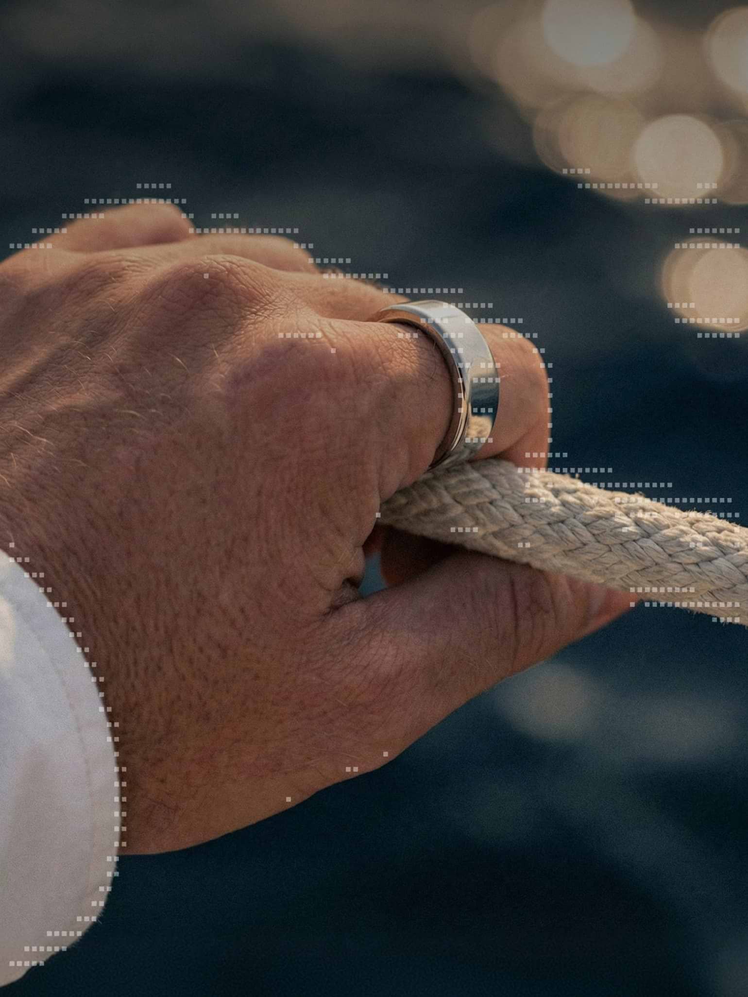 A hand wearing the Ultrahuman Ring, gripping a rope