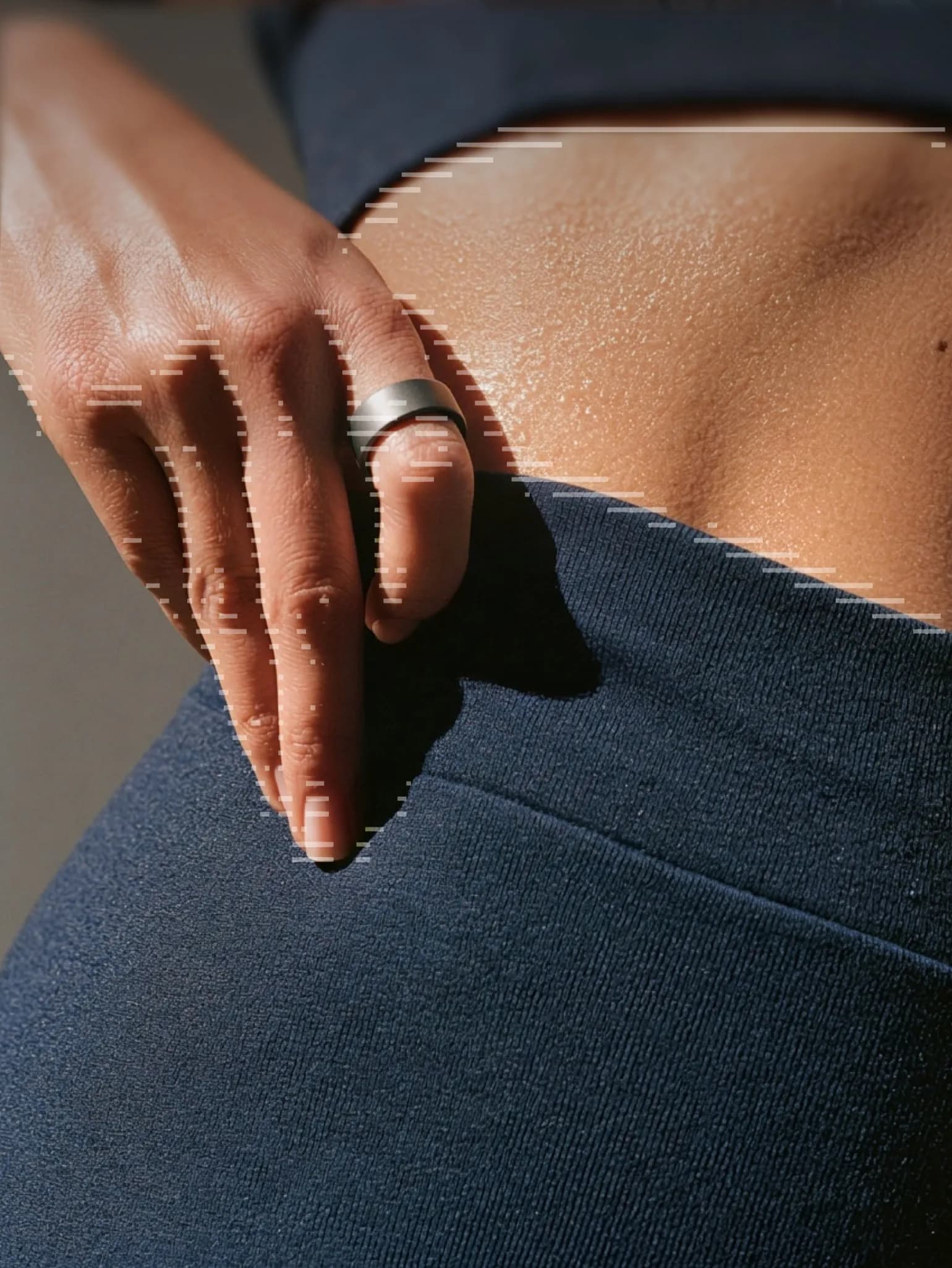 A hand wearing the Ultrahuman Ring resting at the hip