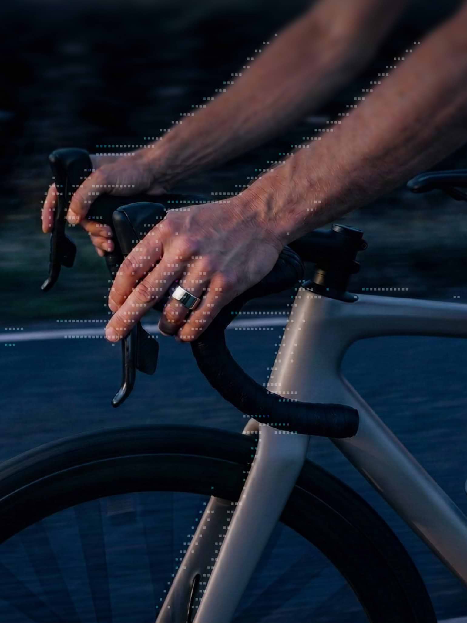 A cyclist’s hands on the handlebars, wearing the Ultrahuman Ring